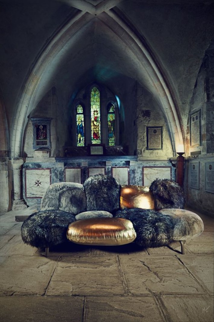 photograph of gold leather and fur contemporary sofa in a gothic cathedral, visual storytelling by marco joe fazio