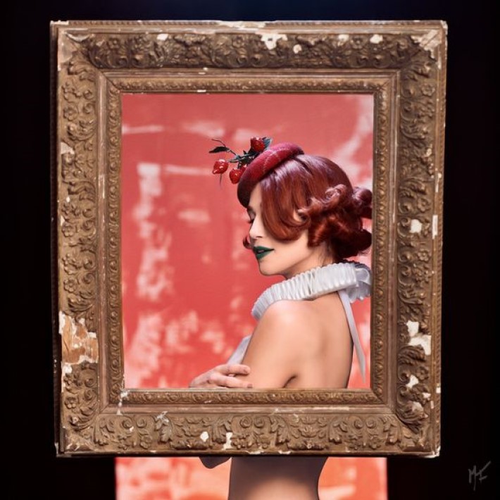 beautiful woman with short red hair wearing a hat and tudor ruff posing in a carved picture frame, visual storytelling by marco joe fazio