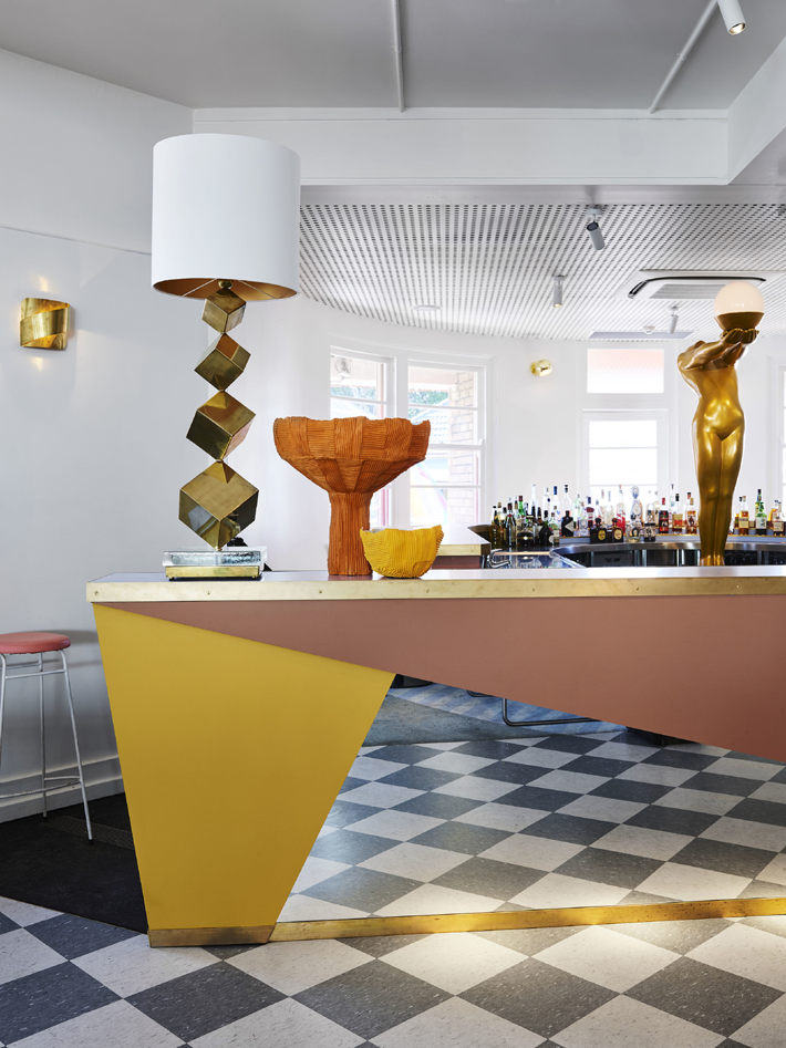 Sculptural gold table lamp on an art deco contemporary yellow, soft pink and mirrored bar at Imperial Up Pizzaeria at the Imperial Hotel Erskineville - Proudly LGBTQIA+