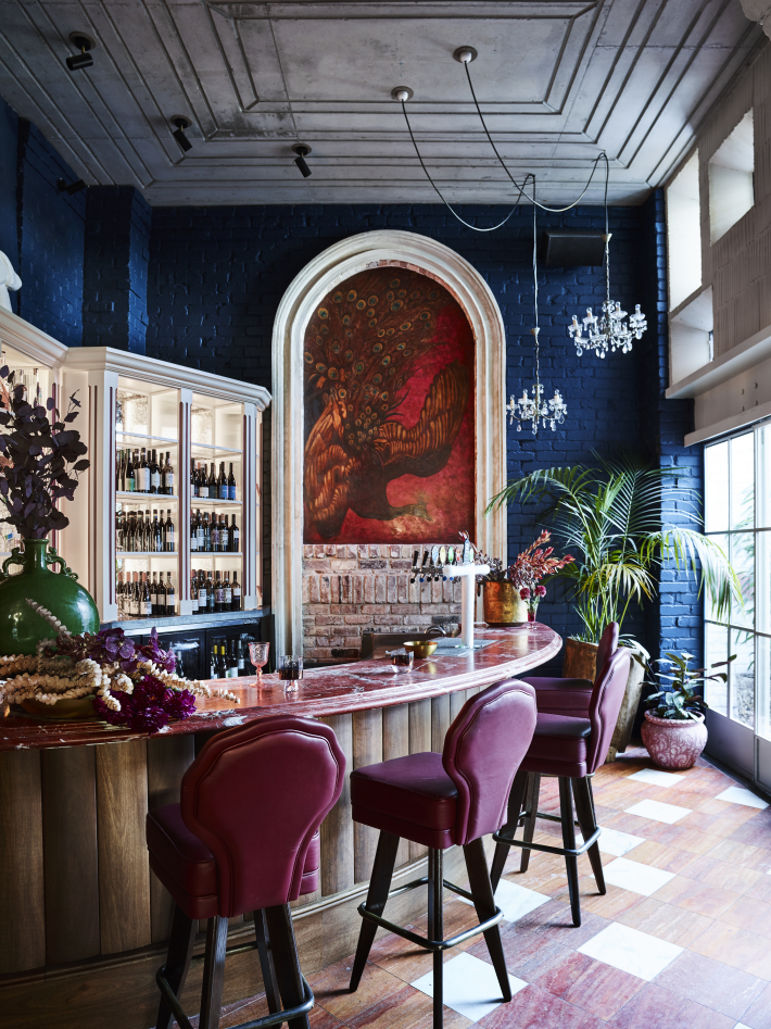 A bar area with blue walls and purple bar stools at the Imperial Hotel Erskineville Sydney Australia - a LGBTQIA+ hotel