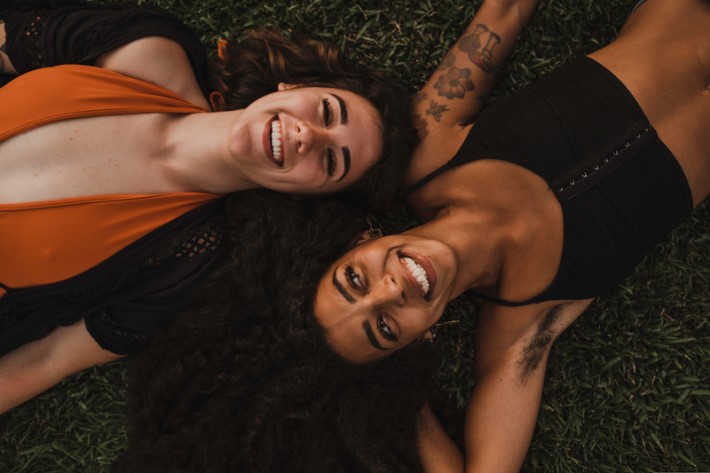 Two women laying on their backs smiling - Natural Beauty - Natural Woman photos by Canva