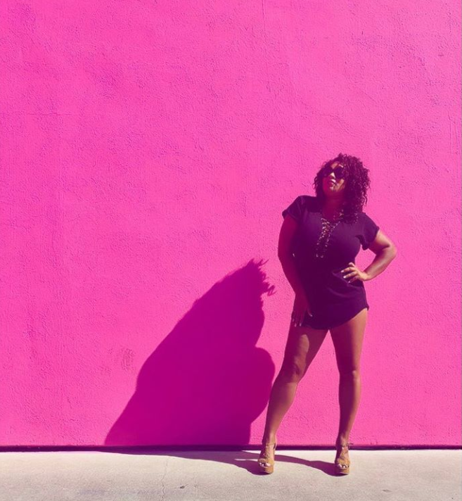 woman standing against a pink wall - 40 things before 40 list