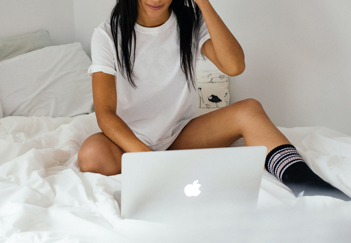 online dating safety tips woman on laptop in bed