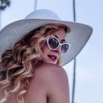 beautiful woman staying young in white sunglasses and hat