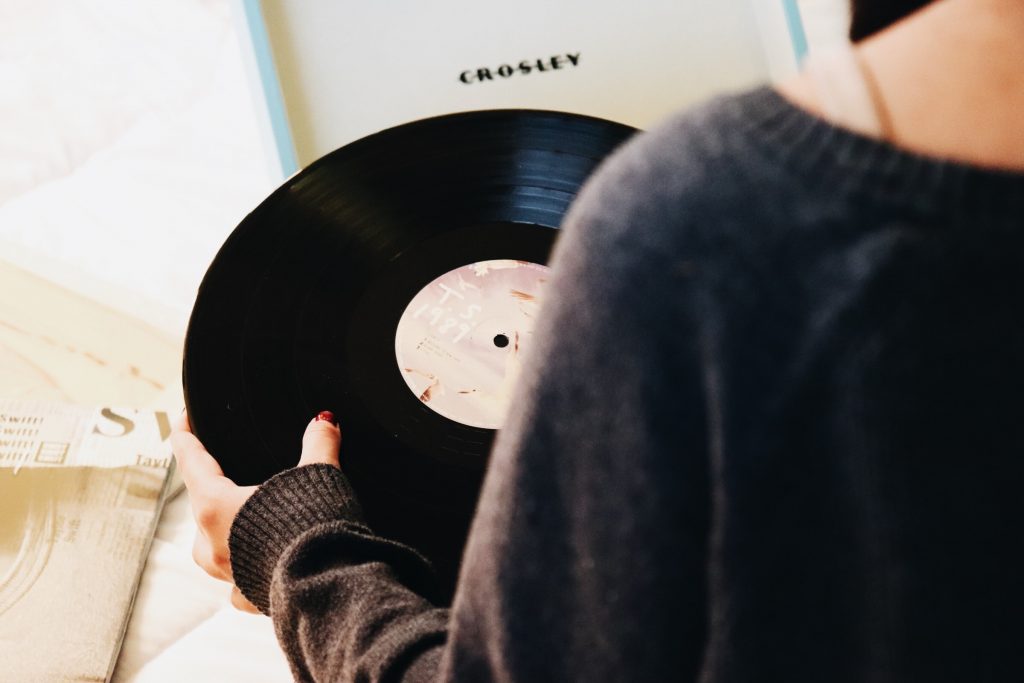 timeless gifts woman holding a record vinyl Photo by Skylar Sahakian