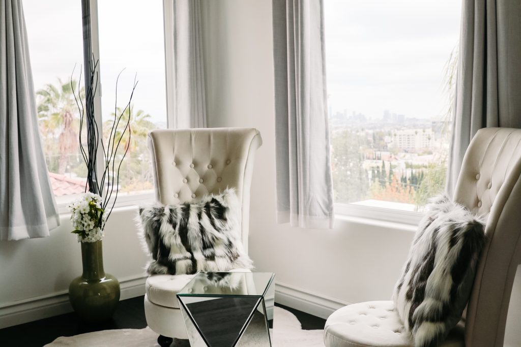 accent chairs in neutral color with fur pillows glamorous sitting room