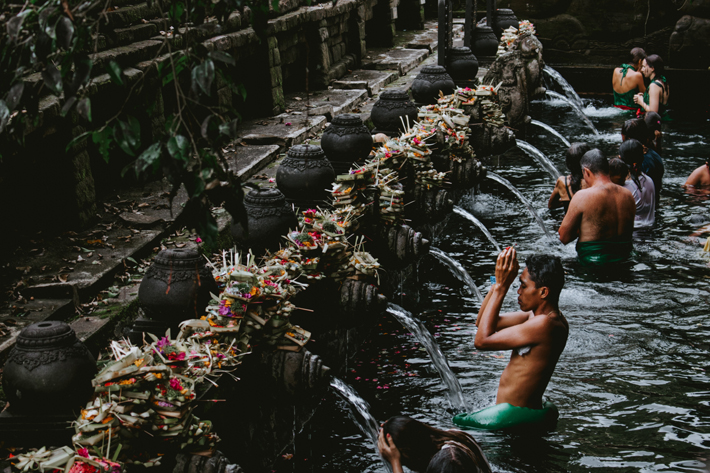 best places to visit in bali boy showering in Tirta Empul (Photo by Florian Giorgio)