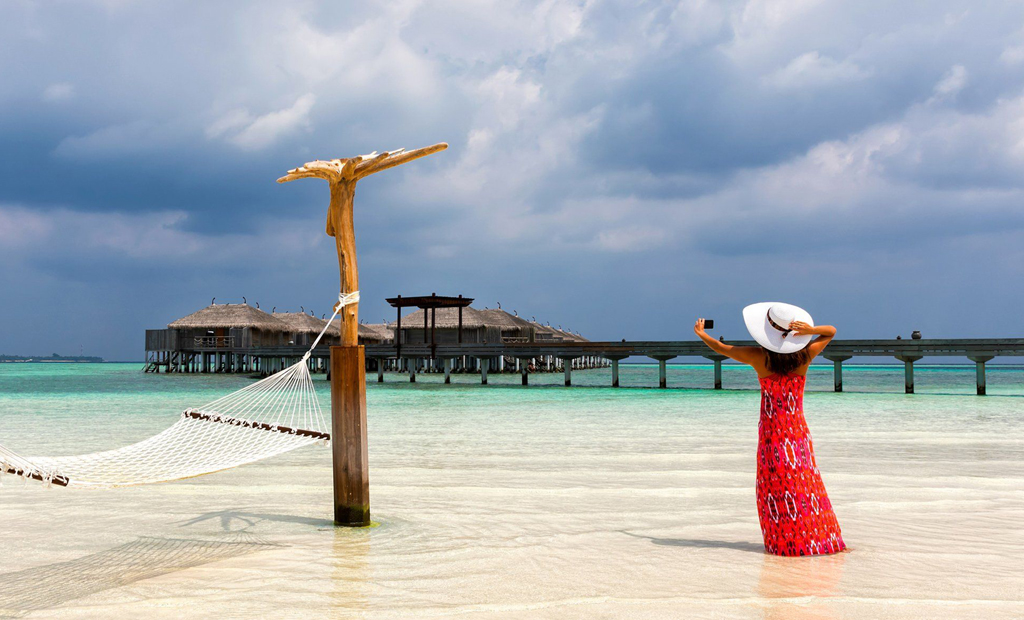 woman on the beach in maldvies luxury resort zeldiva luxury travel