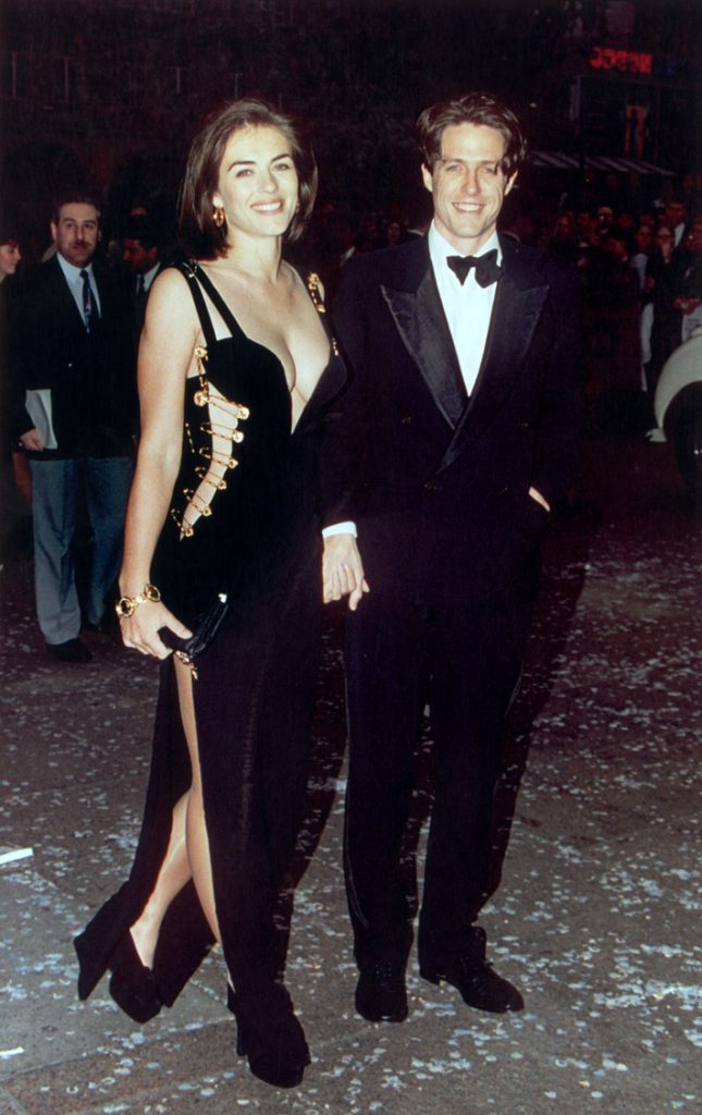 Elizabeth Hurley wearing Gianni Versace with actor Hugh Grant at his film premiere for 'Four Weddings and a Funeral' in London, 11th May 1994. (Photo by Gareth Davies/Mission Pictures/Getty Images)