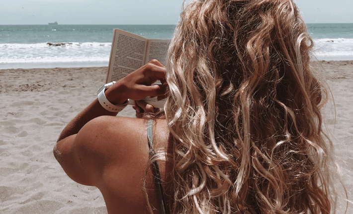 summer beach reads - photo by shannon kelly - woman reading a book on the beach