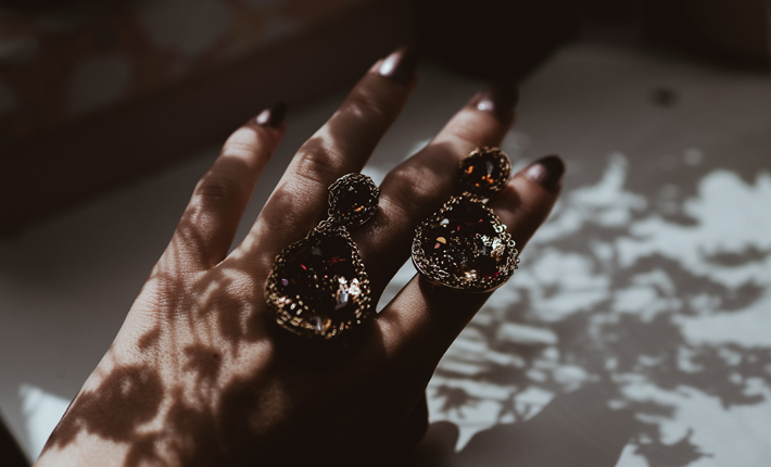 what gemstones say about you hand with earrings on it