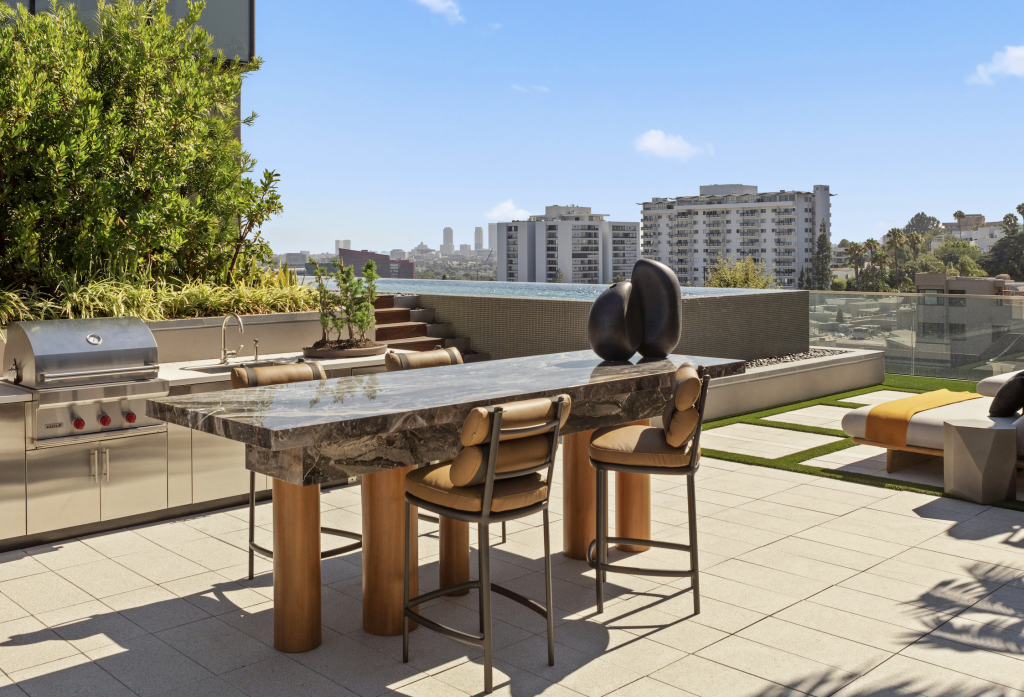 Outdoor grill and lounging area with custom stone table