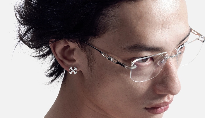 A man wearing a unique pair of handmade earrings