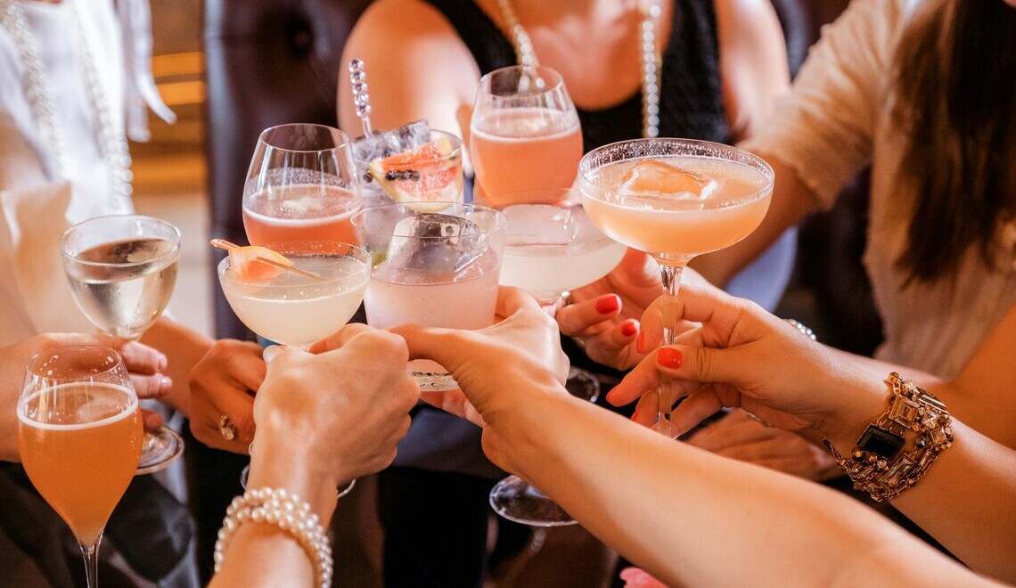 photo of women holding cocktails cheers alyona yankovska unsplash