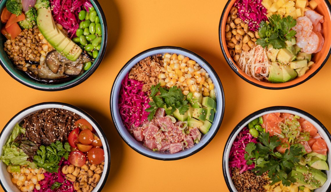 Four bowls of different types of food on a yellow surface