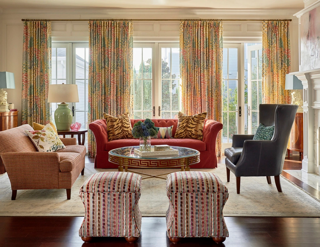 Michael Mitchell living room with zebra print pillows red couch and colorful pouf ottomans | Photo by Dustin Peck