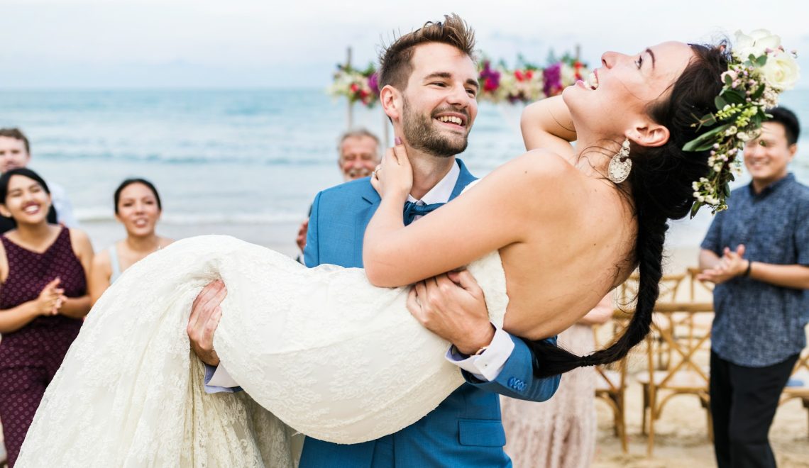 cheerful newlyweds at beach wedding ceremony