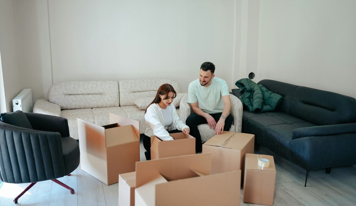 A man and a woman packing things in boxes