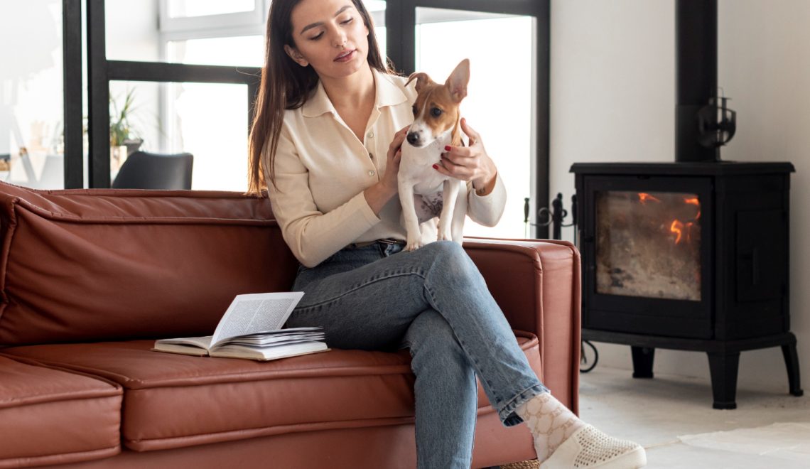 Woman in a couch holding a dog