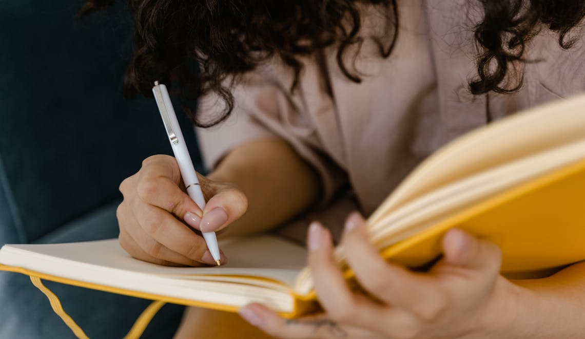 woman writing on white paper
