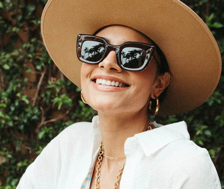 smiling woman wearing sunglasses and a hat