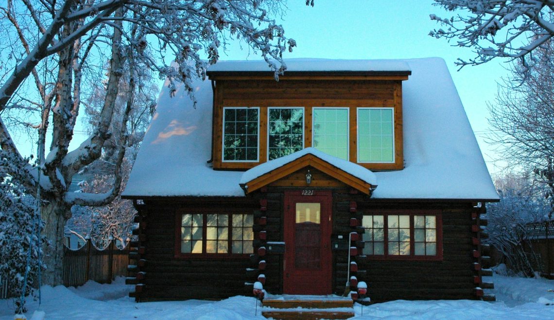 Wooden house covered in snow