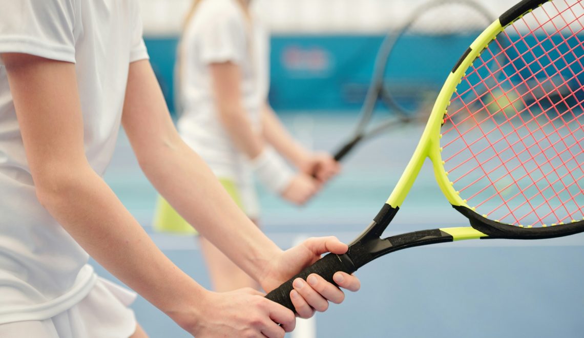 girls holding tennis rackets