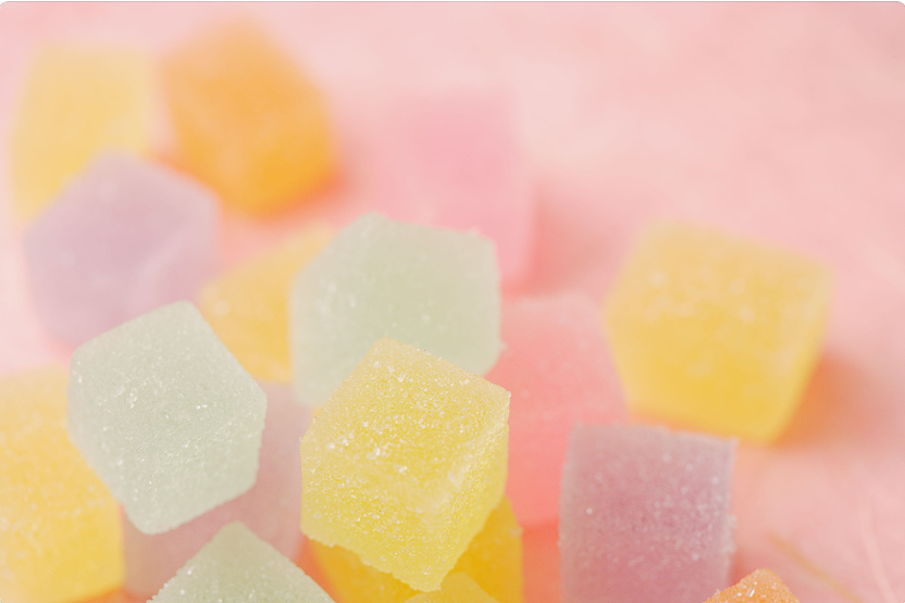 Colorful Jelly THC Edible Cubes on Pink Background