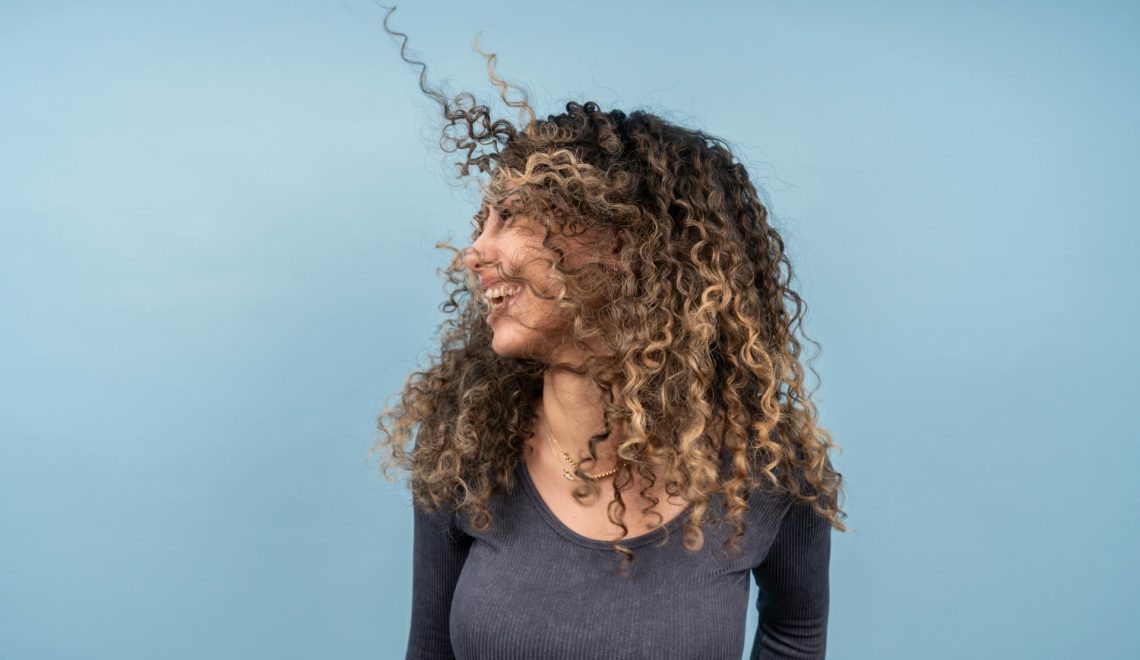 A woman with curly hair smiling