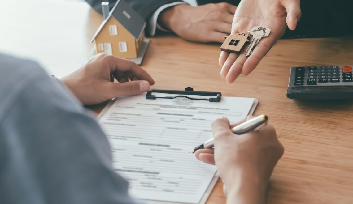 person signing a contract for a new house