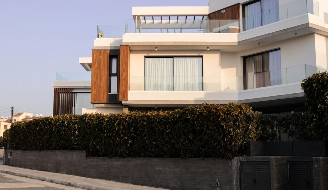 Modern luxury home exterior with glass balconies and contemporary architecture