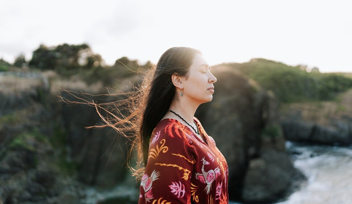 A woman standing in front of a body of water