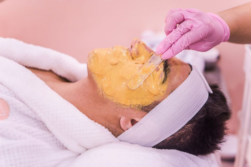 Golden facial mask treatment applied by an esthetician