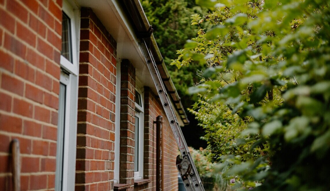 a ladder rests against a brick house