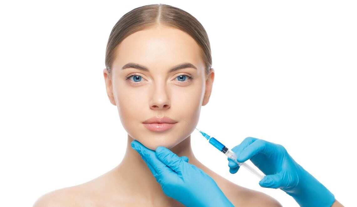 Woman receiving facial cosmetic injection with syringe in a clinical setting