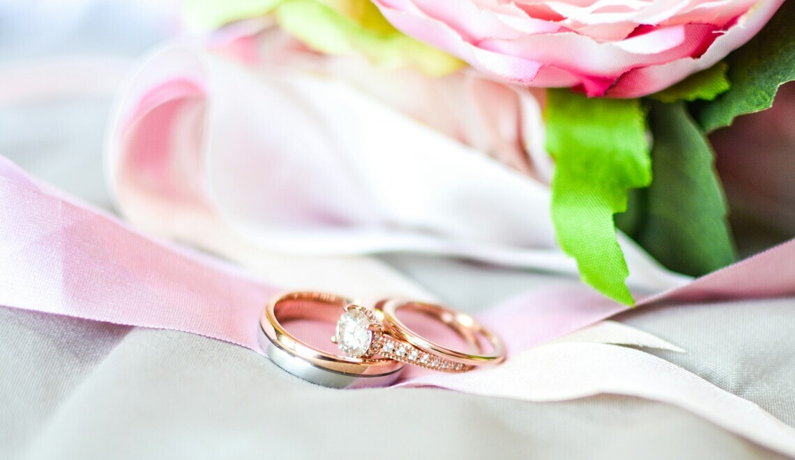 silver and gold colored rings near a pink flower