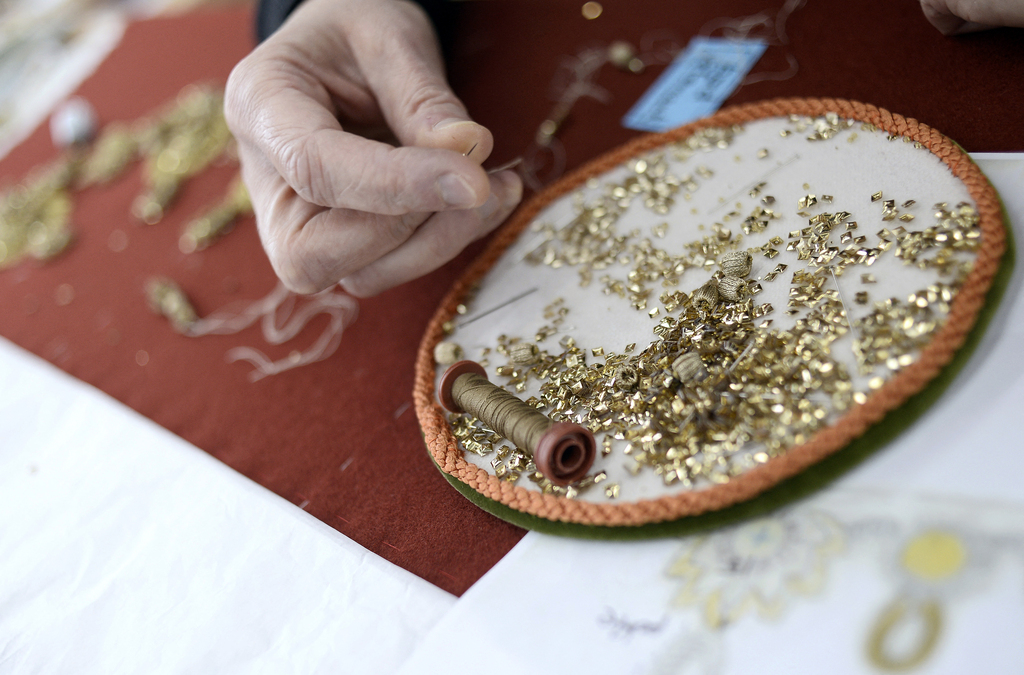 An employee of Lesage house works on an embroidery on November 24, 2014 at Chanel's workshops in Pantin, north of Paris. AFP PHOTO / STEPHANE DE SAKUTIN (Photo by STEPHANE DE SAKUTIN / AFP) (Photo by STEPHANE DE SAKUTIN/AFP via Getty Images)