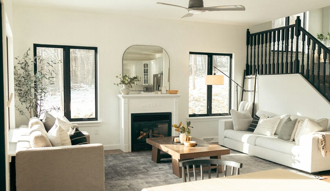 Bright modern living room with neutral decor, fireplace, and large windows for natural light