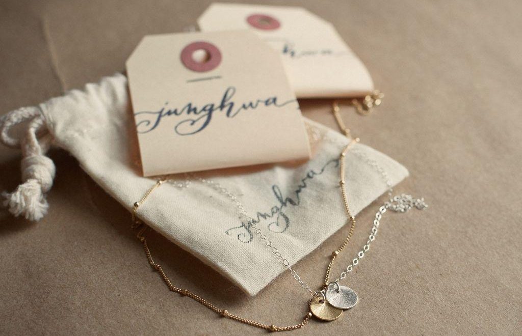 Layered gold and silver disc necklace with jewelry packaging