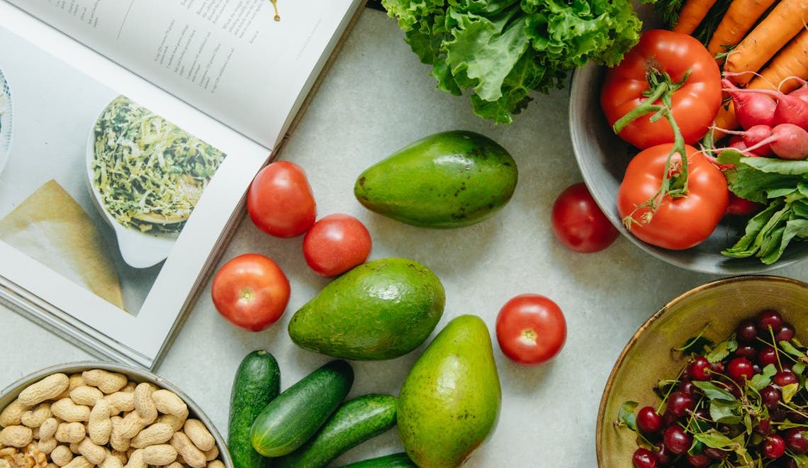 An appetizing display of fresh fruits and vegetables with a cookbook