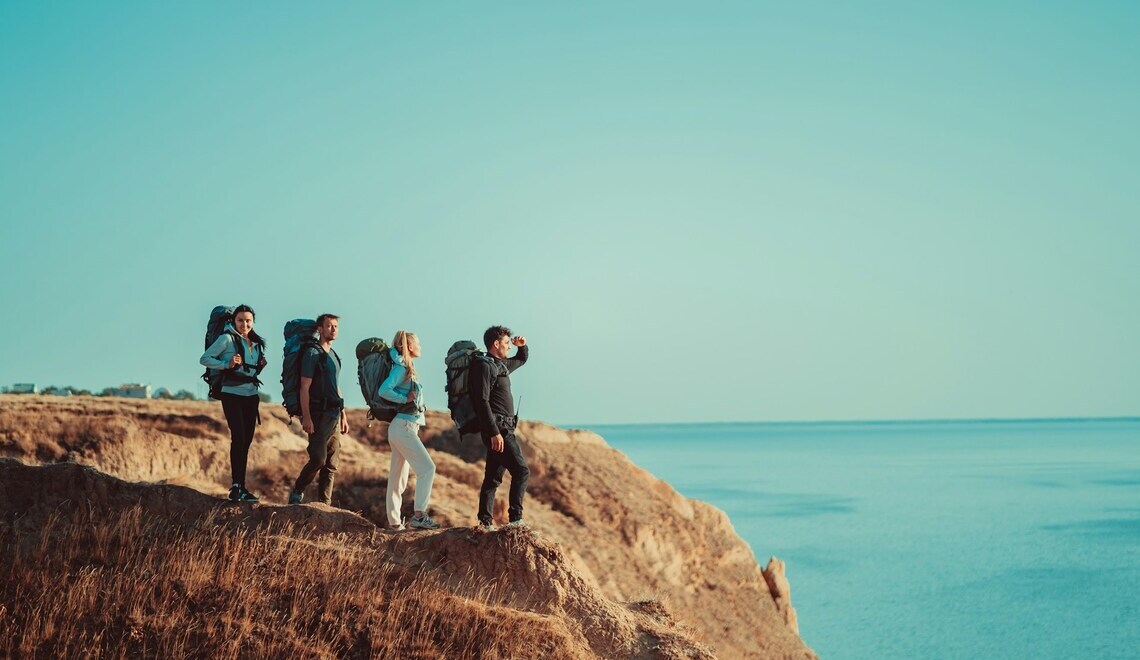 four travelers standing on top of a mountain