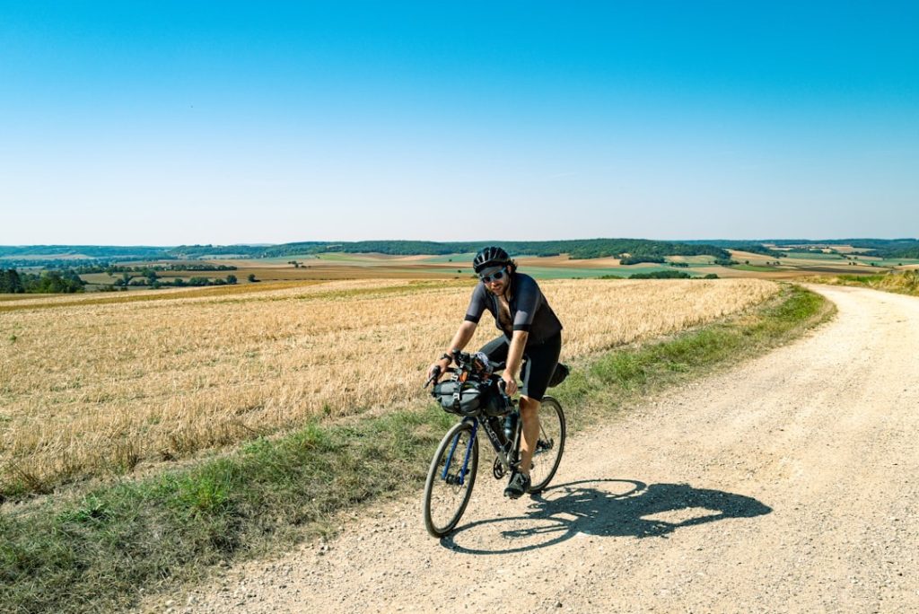 Cyclist in an aero position riding a road bike on a quiet country road