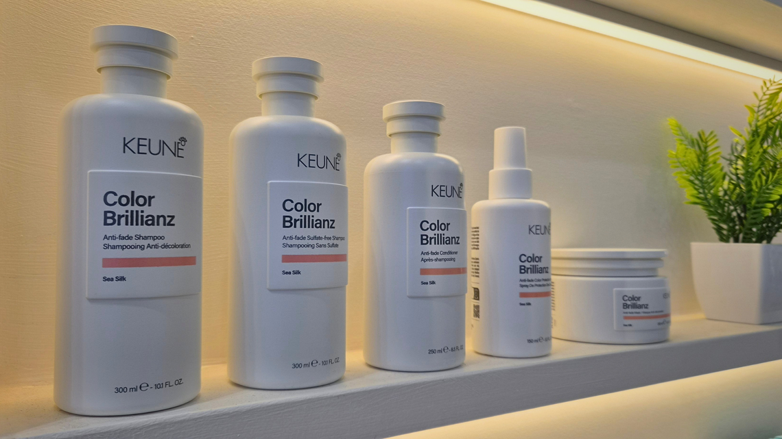 Keune Color Brillianz hair care products lined up on a lighted shelf
