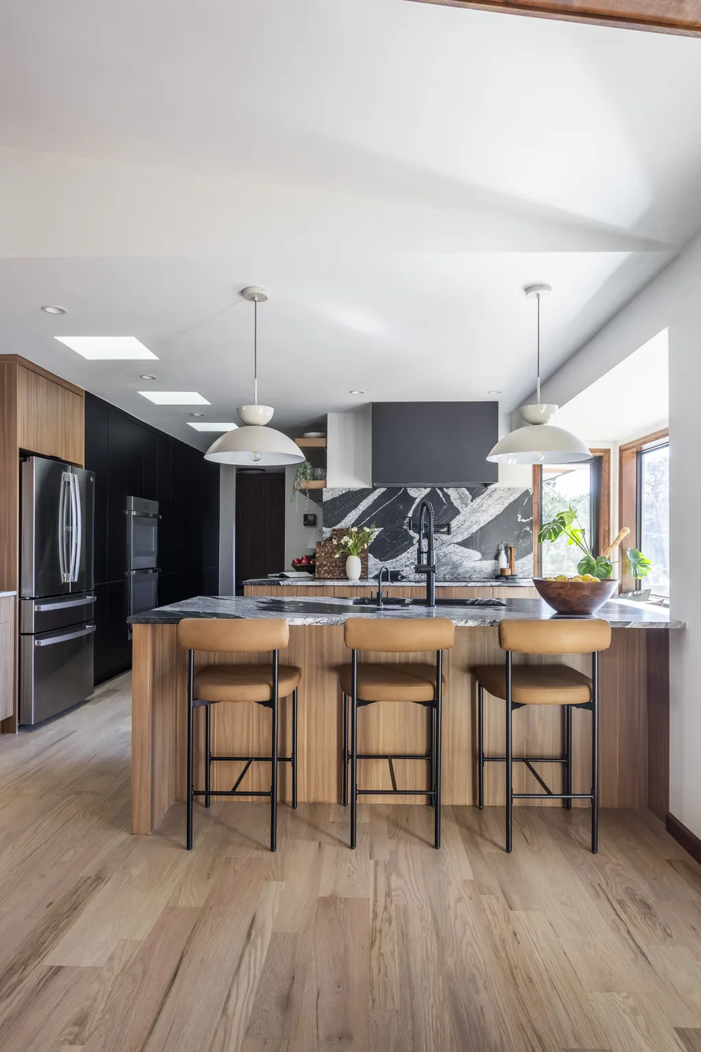 walnut kitchen island with veined stone backsplash in Evergreen Ranch mountain home remodel by sister interior designers