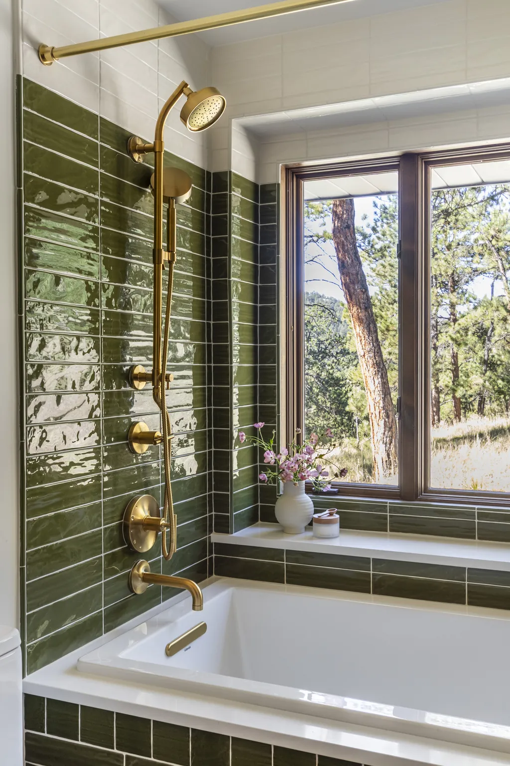 forest green tile bathroom with brass shower fixtures and soaking tub at Evergreen Ranch