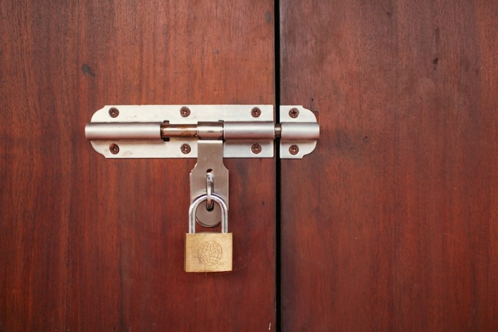 Close up of a stylish brass deadbolt lock on a wooden door