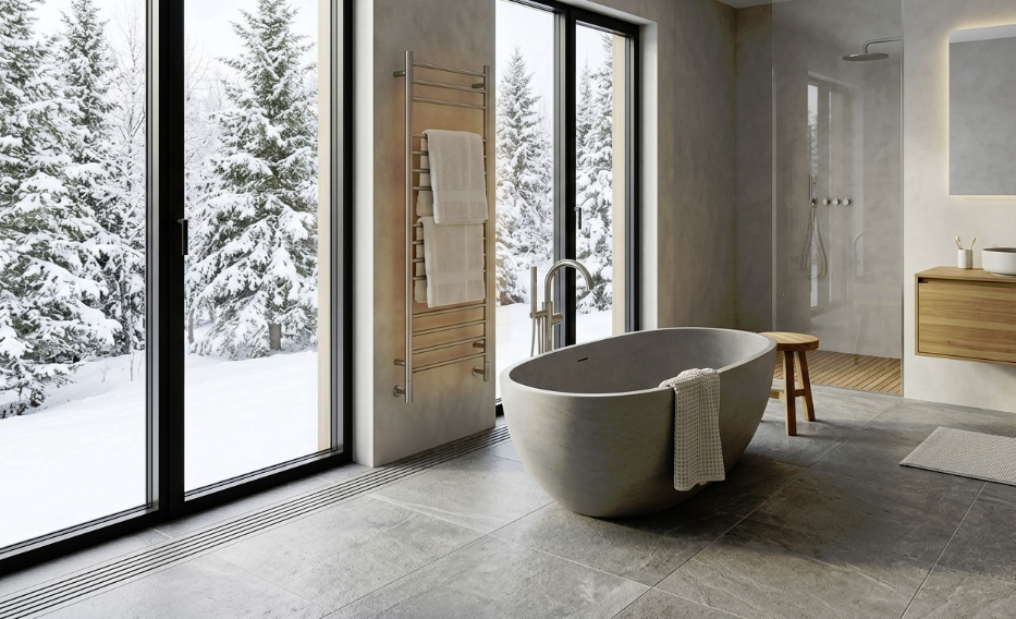 Modern bathroom with freestanding bathtub and floor-to-ceiling windows overlooking a snowy forest
