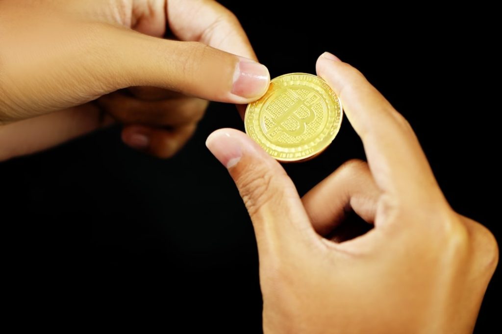 Two hands exchanging a custom coin as a meaningful gift
