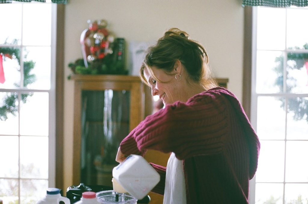 A woman carefully wrapping antique china and small heirlooms in tissue paper