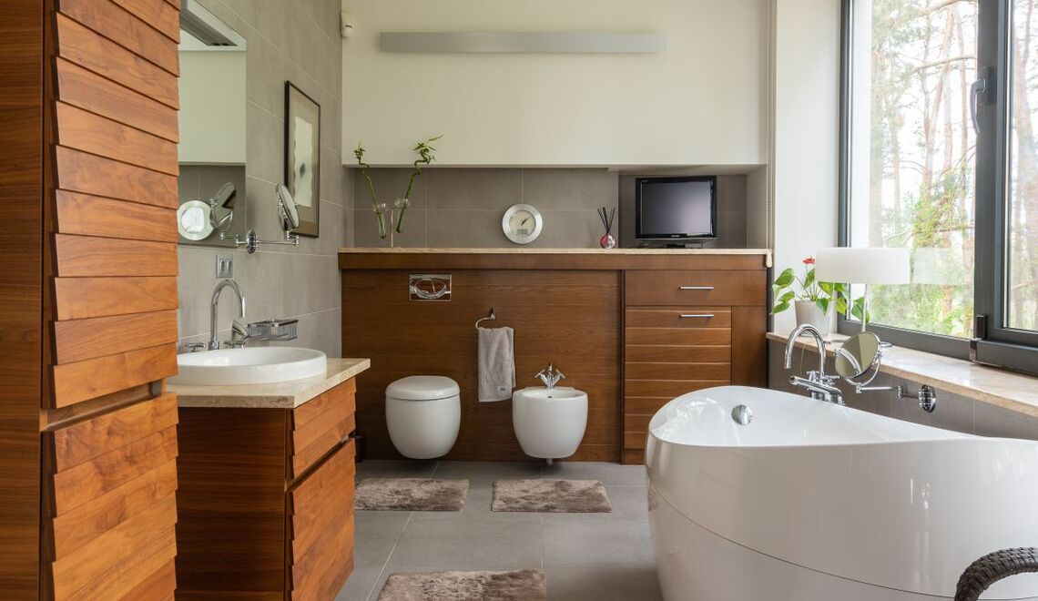 Modern luxury bathroom featuring a freestanding soaking tub, wooden cabinetry, and wall-mounted toilet and bidet